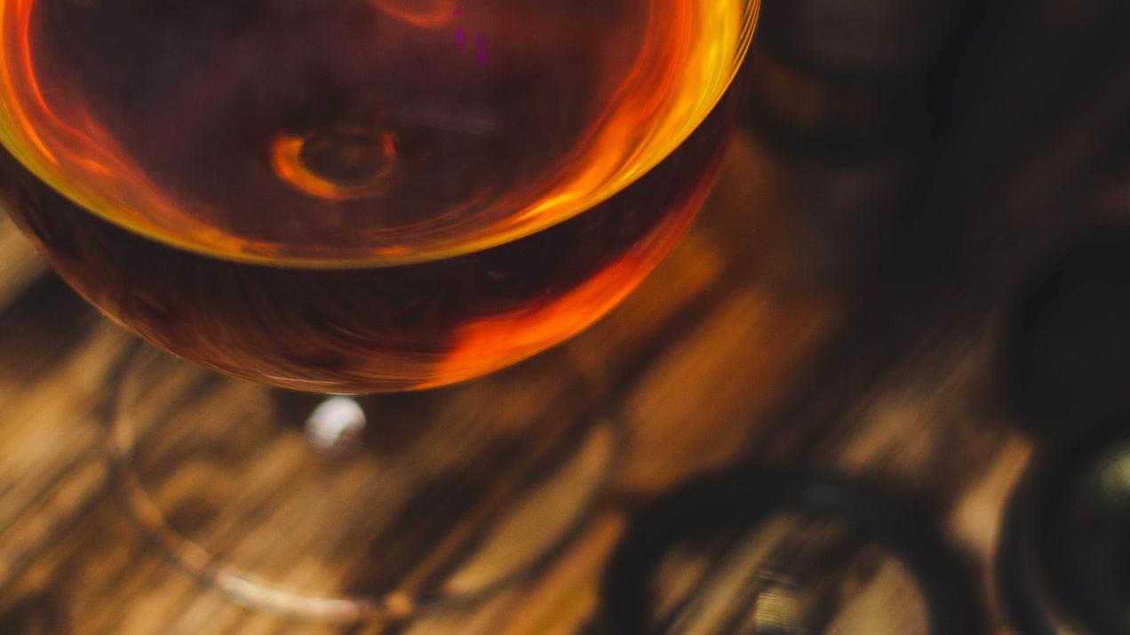 a glass of wine sitting on top of a wooden table