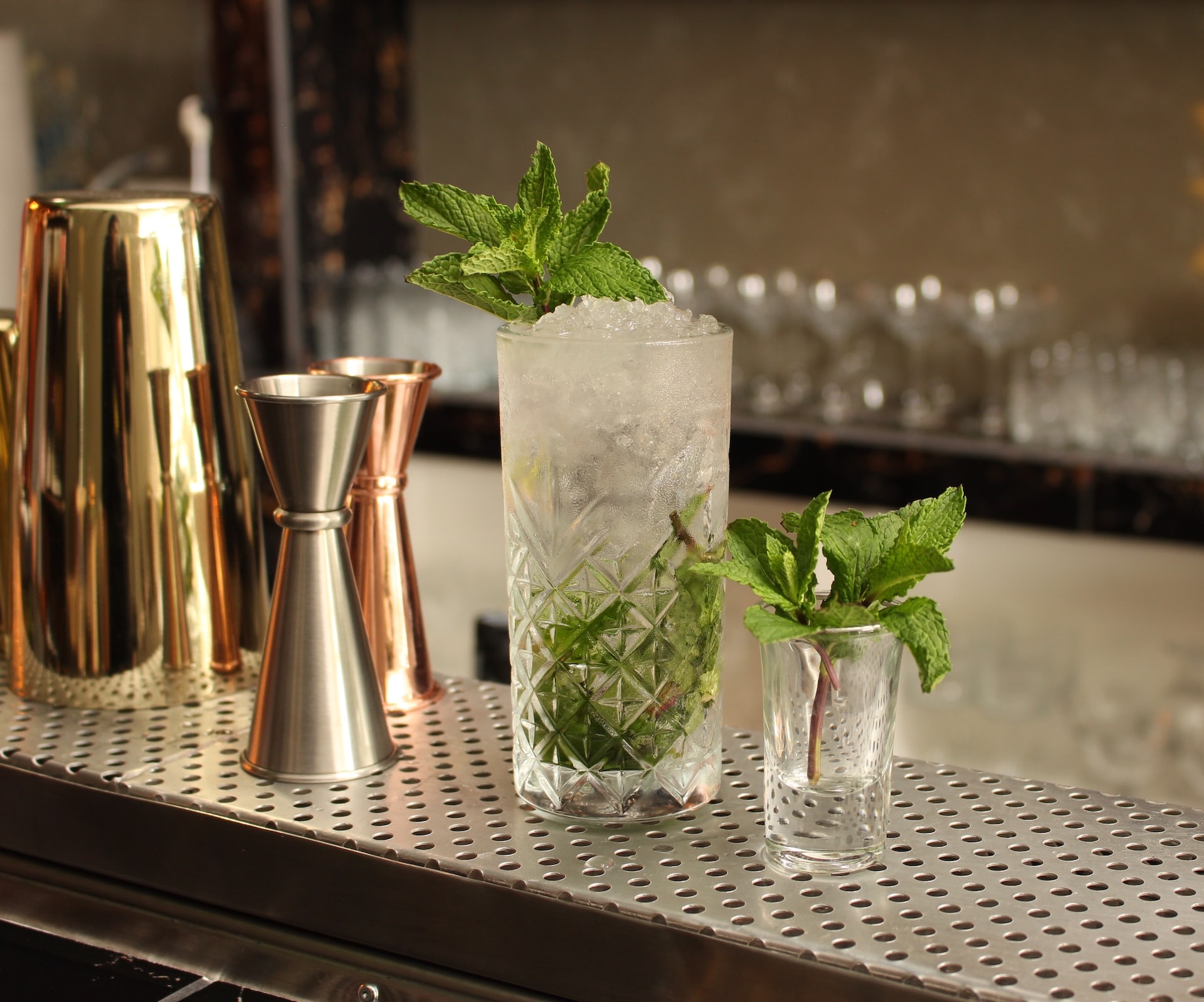 clear drinking glass with green leaves on table