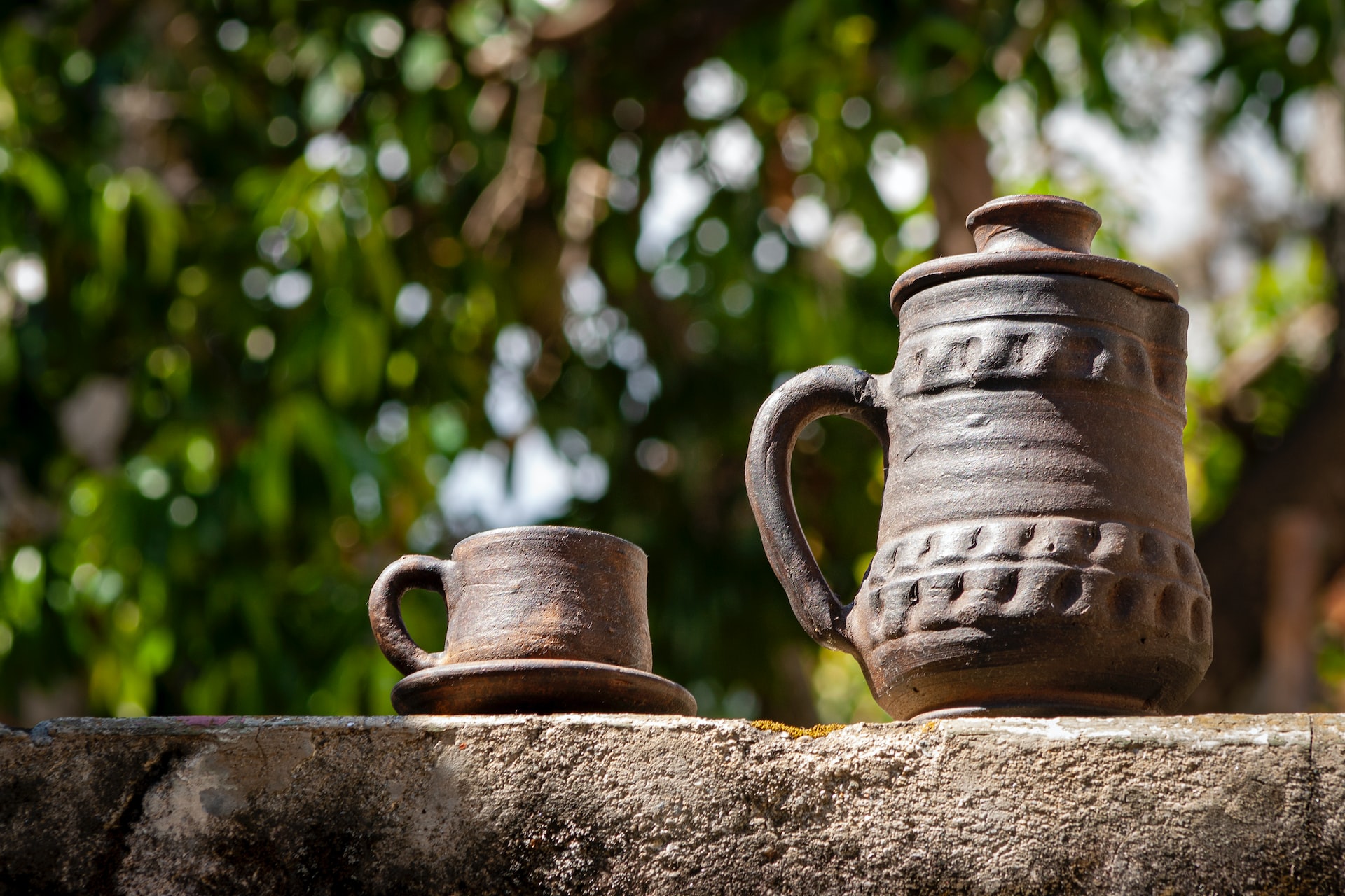 a couple of cups sitting on top of a stone wall