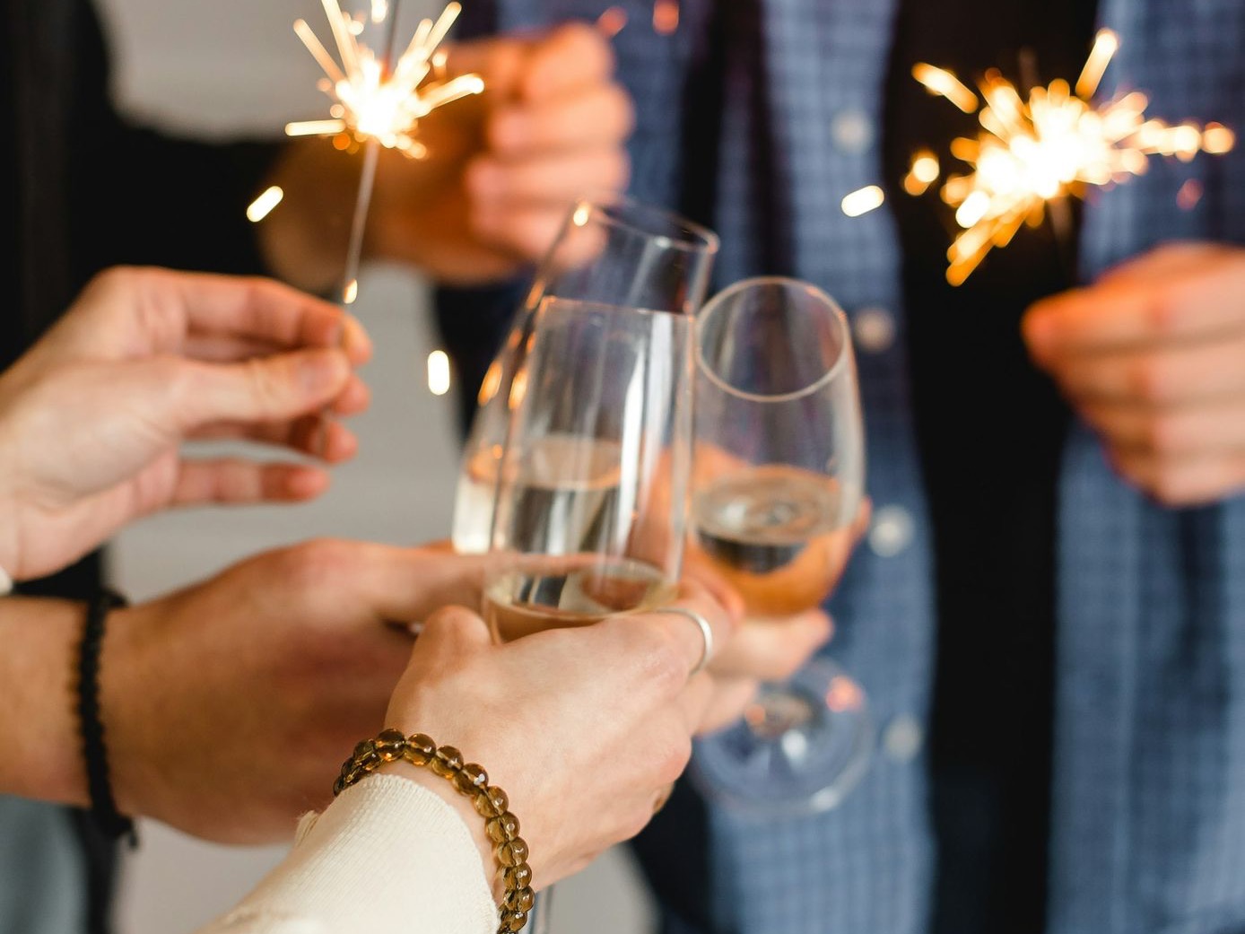 woman in white long sleeve shirt holding clear wine glass